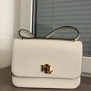 Lauren Ralph Lauren väska  - Använd 2 gånger! Finns en liten repa där man öppnar väskan (finns bild på sista sliden) Nypris 3800kr