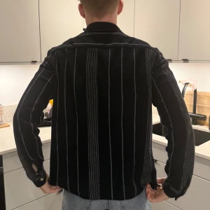 Marinblå och vit randig skjorta - Snygg Marinblå skjorta med vita ränder. Skjortan har långa ärmar och knappar framtill. 