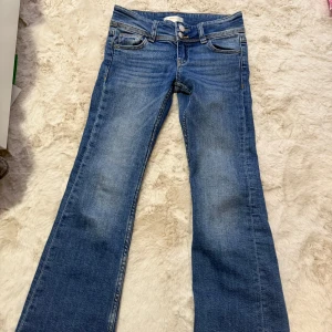 Blå jeans från Gina Tricot young - Snygga blå jeans från Gina Tricot med bootcut-stil. De har en klassisk femficksdesign och knappar framtill. Använda få gånger men väldigt bra skick