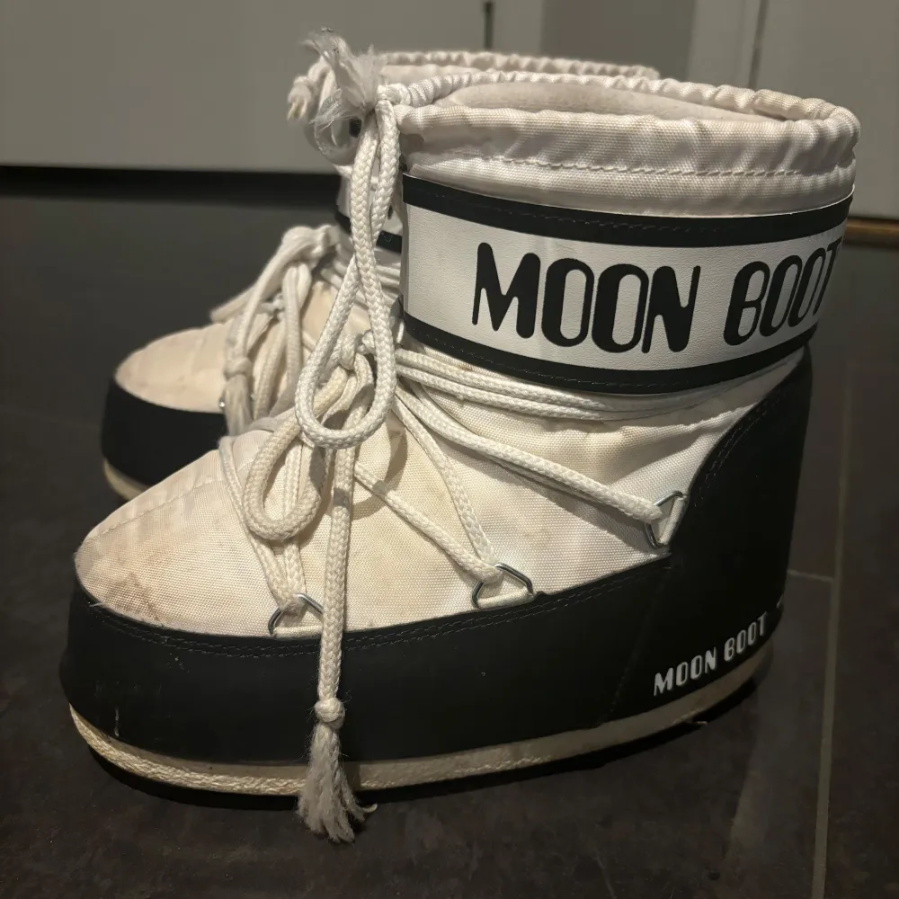 Säljer ett par vita Moon Boots med svarta detaljer. Använda 1 vinter. Strl. är 33-35 men passar mig som har strl. 36-37. Säljer för att jag inte använder längre. Perfekta för vintern och håller fötterna varma och torra. Använda men i bra skick! . Skor.