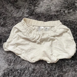 Vita shorts från H&M Divided - Säljer ett par vita shorts från H&M Divided. De är superbekväma med en elastisk midja och dragsko för perfekt passform. Perfekta för en avslappnad dag eller sommarens alla äventyr!