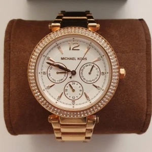 Klocka Michael Kors - Klocka från märket Michael Kors. Rosé färg med lite bling. Oanvänd och är i god skick, har inga defekter. Extra länk följer med. Äkta märkesklocka. 