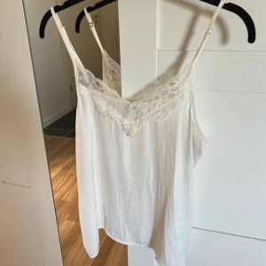 Spetslinne - Spetslinne från jacoueline de yong. Sitter väldigt lätt på kroppen, superskönt. Banden är justerbara och materialet är lite sidenliknande. Passar jättebra med en fin kofta över! Läs bio innan köp! 