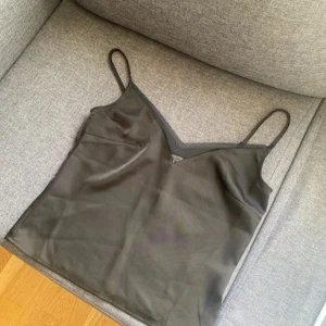 Svart satintopp  - Svart satintopp från Sanne Alexandra i storlek s, köpt på LXAs sample sale. Helt oanvänd med prislapp kvar.