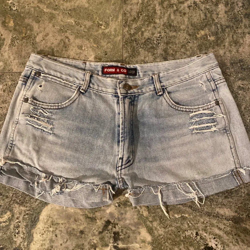 Säljer ett par ljusa jeansshorts från Form & Co. De har en cool distressed look med slitningar på framsidan och fransiga kanter. Lågmidjade ❤️. Shorts.