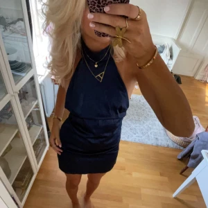 Festklänning  - Säljer en så fin mörkblå klänning från Bikbok! Klänningen är perfekt i längden så man kan röra sig fritt, även knyte i ryggen som går att justera. Har även öppen rygg 💕