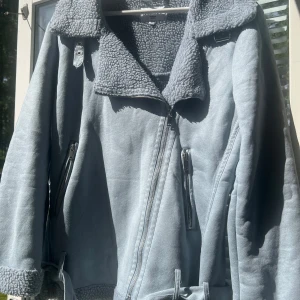 Jacka- NA-KD - En fin ljusblå jacka från NA-KD, storlek 32, oversize, använts men är i bra skicka utan några skador eller fläckar, fina detaljer, och har mysigt och vart material inuti som är perfekt nu är det börjar bli kallare.