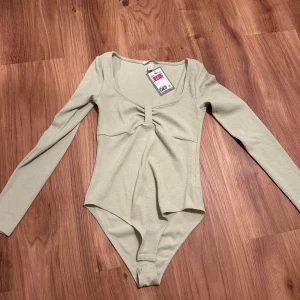Topp - En helt ny body från Hm i storlek S, i en fin grön färg! I mycket bra skick. 