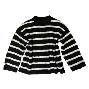 Svart och vit randig stickad tröja - Säljer en superfin svart och vit randig stickad tröja. Den har långa ärmar och en bekväm passform som är perfekt för både höst och vinter. Tröjan är ribbad vilket ger den en extra mysig känsla. Perfekt för att hålla sig varm och stilren! 🖤🤍