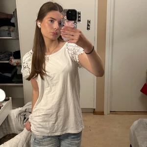 Vit topp med spets - Säljer en superfin lite unik t-shirt med spets. Toppen är i bomull och känns väldigt bekväm att ha på sig. Passar perfekt till jeans eller shorts! Skriv vid frågor!💗
