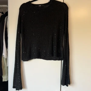 Svart tröja med paljetter  - Fin svart tröja med flowiga armar från bikbok i strl M.