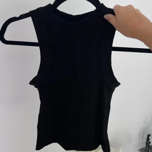 Svart ribbat linne - Ett svart ribbat linne från Zara 🤍 Linnet är i storlek S och är sann i storleken. Använt max 5 gånger 💘 Stretchig!!  Längd: 44 cm Axel: 24 cm Midja: 62 cm