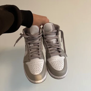 Air Jordan 1 Mid  - Nike Air Jordan 1 Mid i grå färg. Skorna är i gott skick då dem är använda bara ett par gånger. Säljer de pga fel storlek, jag har 41 men de passar 40. Ny pris 3200kr, köpta på Pardon my kicks i Göteborg. Kan gå ner i pris vid snabb affär🌸
