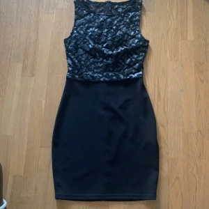 Svart klänning från Amisu - Säljer en elegant svart klänning från Amisu i storlek S. Klänningen har en ärmlös design med ett vackert spetsmönster på överdelen och en tight passform. Perfekt för festliga tillfällen!