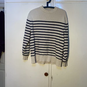 Randig tröja från Zara - Säljer en snygg randig tröja från Zara i beige och svart. Tröjan har långa ärmar och en ribbad struktur som ger en skön passform. Perfekt för en stilren look.