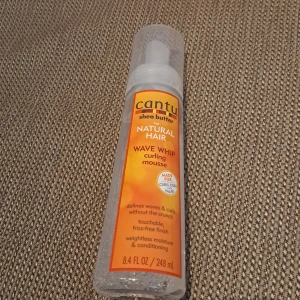Cantu Wave Whip Curling Mousse - Cantu Wave Whip Curling Mousse med sheasmör för naturligt hår. Definierar vågor och lockar utan att bli krispiga. Ger en mjuk och frizzfri finish med viktlös fukt och vård. Innehåller 248 ml. Oõppnat och oanvänt