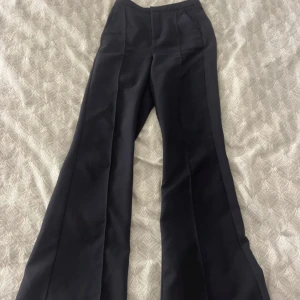 kostymbyxor från Gina Tricot - Snygga kostymbyxor från Gina Tricot i storlek XXS. Byxorna har en elegant bootcut-stil som ger en stilren look. Använd enstaka gånger så super fina!