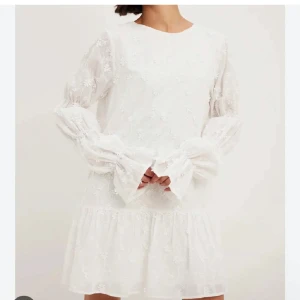 Vit klänning/ student - Vit klänning med blomdetaljer. Öppen rygg med knytband och långa ärmar. Använd en gång på min student, så den är fortfarande i fint skick. Storlek: 36/S. Alltid öppen för prisförslag🤍