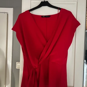 Röd omlottblus från Zara - Snygg röd omlottblus från Zara med korta ärmar och fin detalj i midjan. Perfekt för fest eller till vardags🎀🥂kontakta innan eventuellt köp🙏