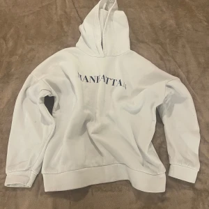 Hoddie  - Vit hoddie ifrån boohoo med text ” Manhattan”. Storleken är one size, hade sagt att den är oversized.