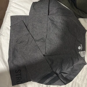 Grå långärmad tröja från Stronger - Säljer en grå långärmad tröja från Stronger. Helt ny. Sitter snarare som en Xs/S