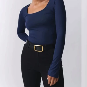 Mörkblå långärmad topp från Gina tricot - Snygg mörkblå långärmad topp från Gina tricot  med en djup rundad halsringning. Perfekt för en stilren look och kan enkelt matchas med olika outfits. 