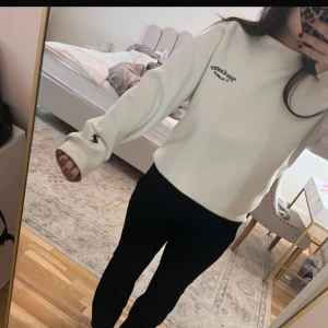 Vit sweatshirt från Juicy Couture  - Säljer en vit sweatshirt från Juicy couture med tryck på bröstet. Tröjan har långa ärmar och en avslappnad passform. Perfekt för en casual look.