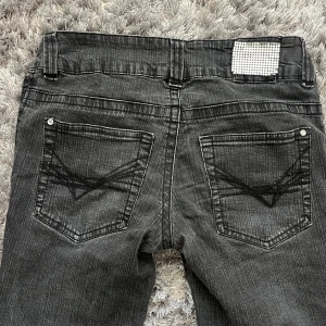 lågmidja bootcut jeans  - sjukt snygga lågmidjade bootcut jeans med coola detaljer🥰Dom är använda och har därmed lite defekter. Två små hål, se bild 4🥰Ett igensytt hål, se bild 5, dock gjort på ett bra sätt så man knappt ser🥰Skriv för frågor!