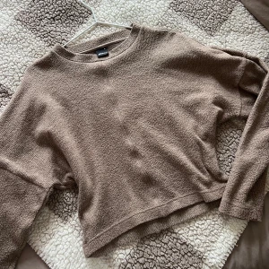 Beige/brun tröja från Gina Tricot, M - Söt och mysig lite cropped tröja i en härlig brun nyans. Tröjan har en avslappnad passform och långa ärmar. Perfekt för höst- och vinterdagar! I nyskick från Gina tricot.