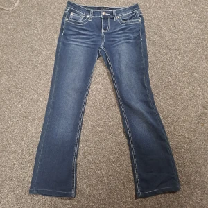 Blå jeans med broderade bakfickor - Snygga blå jeans från earljean med unika broderade detaljer på bakfickorna. De har en klassisk femficksdesign och en bekväm passform. Perfekta för en stilren look med det lilla extra. Dom är lågmidjade och flare och ger en y2k och miss me vibe.