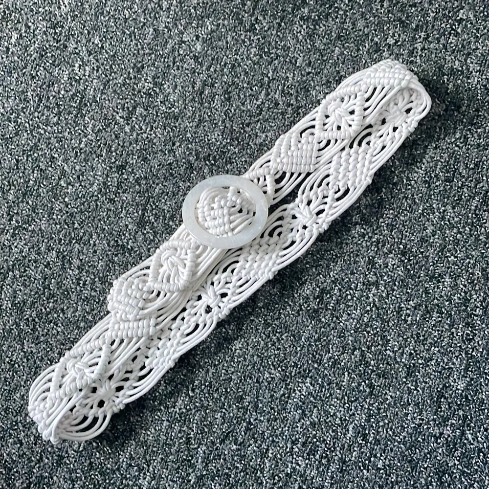 Snyggt vitt flätat bälte med ett unikt mönster och rund spänne. Perfekt för att ge en bohemisk touch till din outfit. Passar bra till både klänningar och jeans. Ett måste för den stilmedvetna!. Muu.