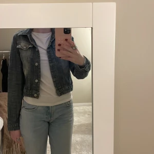 Mörkblå croppad jeansjacka - Snygg mörkblå croppad jeansjacka med knappar framtill. 
