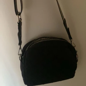 Svart quiltad axelväska/ med fint mönster i den -  Snygg väska i bra skick. Har aldrig använt🤍Skriv om ni vill veta mer🤍