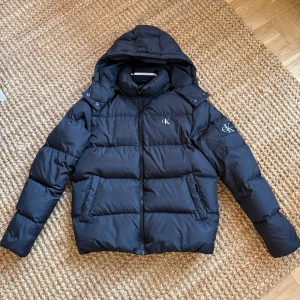 Calvin Klein puffer jacka M - Ck puffer jacka i storlek m. Mycket bra skick utan defekter och använd fåtal gånger. Jag köpte jack ny för runt 3000kr säljer nu för 1900