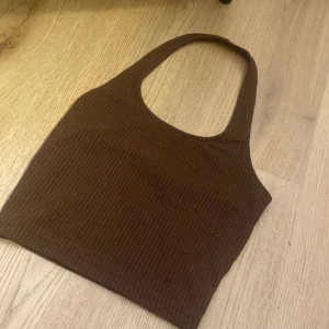 Brun ribbad linnetopp från H&M Divided - Säljer en brun ribbad linnetopp från H&M Divided. Toppen har en enkel och stilren design med breda axelband och är perfekt för en avslappnad look.