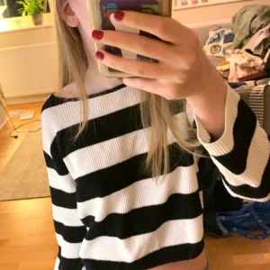 Randig croppad tröja - Säljer en svartvit randig croppad tröja med långa ärmar. Perfekt för en avslappnad stil. Tröjan har en ribbad textur som ger en extra touch.🤍🖤