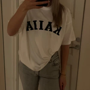 Vit t-shirt med tryck - Kaiia t shirt, köpt från Asos! Är i storlek 32 men väldigt oversized så är mer en 36!
