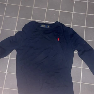 Mörkblå tröja från Polo Ralph Lauren - !PRISET ÄR FÖRHANDLINGSBART! Säljer en stilren mörkblå tröja från Polo Ralph Lauren med det klassiska röda logotypbroderiet på bröstet. Tröjan har en normal/slim passform och är perfekt för en avslappnad look. Den passar S men funkar för XS också. Modellen i bilden är 173cm och väger 65kg 
