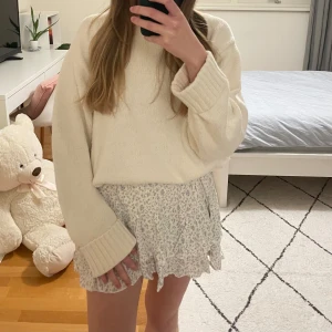 Vit stickad tröja från Brandy Melville - Mysig vit stickad tröja från Brandy Melville. Perfekt för kyligare dagar med sin bekväma passform och ribbade detaljer vid hals, ärmslut och nederkant. En stilren och enkel design som passar till det mesta.