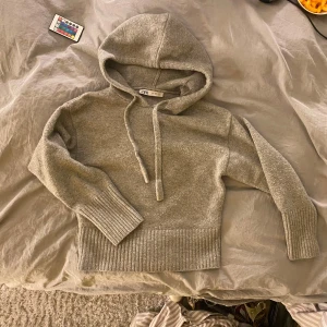 Grå hoodie från Zara - Mysig grå hoodie från Zara med huva och ribbade muddar. Enkel och stilren design som passar till det mesta.