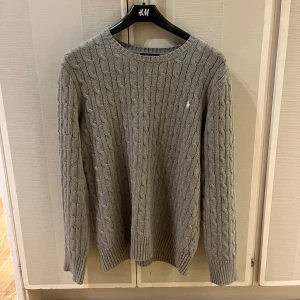 Stickad Ralph Lauren tröja (Grå). Storlek XL.  - Det är en stickad Ralph Lauren tröja som är grå och i väldigt bra skick. Storleken är XL men passar även L bra. 