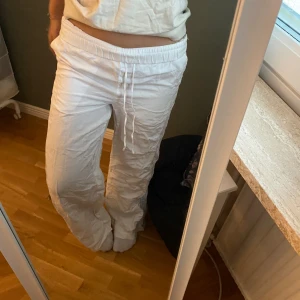 Vita mjukisbyxor med snörning - Säljer ett par vita linnebyxor från HM! De har en loose passform och snörning i midjan för bästa komfort. pris kan diskuteras💋