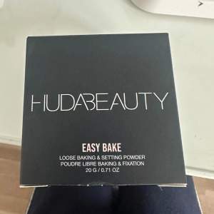 Säljer en Huda Beauty Easy Bake Loose Baking & Setting Powder i nyansen 'Cupcake'. Denna puder är perfekt för att sätta sminket och ge en jämn finish. Förpackningen innehåller 20 g och är superlätt att använda för att få en flawless look. Perfekt för att använda under ögonen och i T-zonen för att hålla sminket på plats hela dagen.