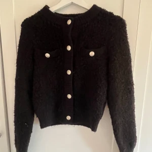 Svart cardigan  - H&m kofta i svart med knappar. Stl xs. Använd fåtal gånger,inga defekter. 