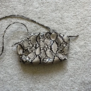 Ormskinn väska - Perfekt skick! Väskan är 25x16cm och har ett långt band som man kan ha tvärs över överkroppen.🫶🫶