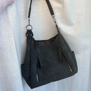 Mörkgrå väska - Mörkgrå väska i mycket bra skick. Finns dragkedjefack på både utsidan och insidan. Måtten är ca 33x24x8 cm.☺️