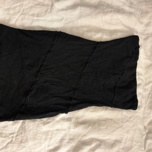 Svart ribbad minidress från Princess Polly - Snygg svart ribbad klänning från Princess Polly i en tight passform. Klänningen har en stilren design med diskreta sömmar som ger en fin struktur. Svinbra på utekväll! Aldrig använd.