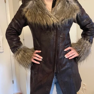 Brun skinnjacka med pälsdetaljer  - Snygg brun skinnjacka från Mayo Chix med pälsdetaljer. Jackan har en lång passform och broderad text på ryggen. Tryck gärna på köp nu. Skriv om ni har frågor 💕