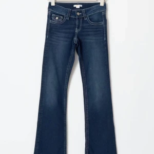 Gina tricot mörkblå bootcut jeans - Snygga mörkblå bootcut jeans med vita sömmar och klassisk femficksdesign. De har en låg midja och en knappgylf. Perfekta för en avslappnad stil. Jeansen är köpa för 359kr ifrån gina tricots barn avdelning och är i storlek 170, dock så skulle jag säga att de mer är som xs/s 