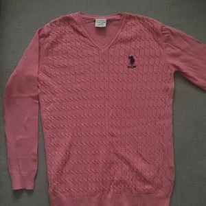 Rosa stickad tröja med v-ringning - Säljer en rosa stickad tröja från US polo assn. Storlek 146-152 men passar även xs. Inte mycket använd. 